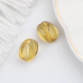 Macro detail of amber glass coffee bean beads with gold foil for DIY jewelry making - Transparent Yellow (00140301)