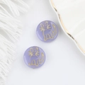 Macro shot of purple Czech glass beads with golden cat patterns for DIY jewelry making - Lavender