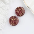 Macro view of burgundy Czech glass beads with gold-rimmed cat motif for DIY jewelry - Reddish Brown