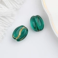 Macro shot of green translucent oval glass beads with gold foil inlay for jewelry making - Ocean Green (00140401)