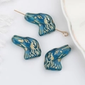 Dettaglio di perla di vetro blu a forma di cane con accenti dorati per gioielli e bracciali - Blu