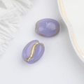 Macro detail of purple Czech glass oval beads with gold-painted vintage textures for DIY - Jade Purple (00141001)