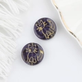 Macro view of purple Czech glass beads with double-sided gold cat motif for DIY - Purple