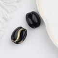 Detail view of coffee bean shaped glass beads with elegant gold hand-painted grooves - Black (00141101)