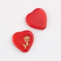 Detail of two red heart-shaped glass beads with gold rose pattern for DIY jewelry - Red