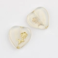 Macro shot of Czech glass heart beads with gold rose inlay and vertical drill holes - Clear