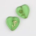 Macro shot of green heart-shaped glass beads with gold flower pattern for DIY jewelry - Green