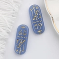 Macro detail of blue glass beads with gold Egyptian runes for DIY jewelry making - Light Purple