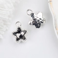 Macro shot of 11mm star charms featuring faceted gray zircon and hammered silver texture - Silver Base Black