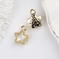 Close-up of alloy star charms with hammered gold finish and zircon stones for DIY jewelry - Gold with White