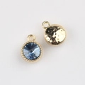 Detail view of round gold-plated pendant with blue crystal and hammered metal back - Gold Base Blue Stone