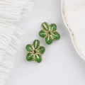 Detailed view of two green glass flower beads with vintage gold gilded edges for DIY crafts - Green