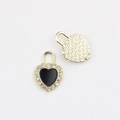 Macro detail of heart lock pendant with zircon inlay and gold star patterned back - Gold Black