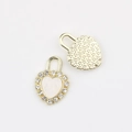 Detail of heart lock pendant with white stone inlay and starry texture on back - Gold White