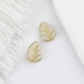 Macro detail of leaf-shaped Czech glass beads with double-sided gold-painted veins - White