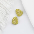Macro detail of leaf-shaped glass beads in green with delicate golden vein patterns - Yellow