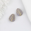Detailed macro view of Czech glass beads with lavender drop shape and gold leaf vein patterns - Purple