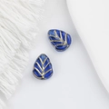 Detailed macro view of Czech glass leaf beads with gold veins for DIY jewelry making - Blue