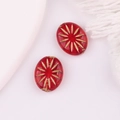Detailed view of red oval Czech glass beads with gold hand-painted firework star pattern - Transparent Red