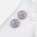 Detailed macro of lavender glass beads with vintage gold duck patterns for jewelry DIY - Purple