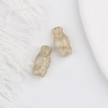 Close-up of vintage translucent owl beads with gold-painted details for DIY jewelry - White