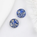 Macro view of two blue Czech glass beads with golden bird patterns for DIY jewelry - Blue