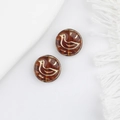 Macro shot of two amber glass duck beads with gold engraved birds and white tassels - Transparent Brown