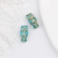 Macro shot of two vintage lake blue glass owl beads with gold gilded detailing - Light Blue Zircon