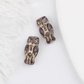Detailed view of two vintage purple Czech glass owl beads with gold accents on white - Dark Purple