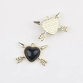 Macro shot of gold alloy and black resin heart charms with cupid arrows for DIY jewelry - Gold Black