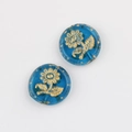 Macro shot of blue Czech glass beads with gold sunflower pattern and gold foil accents - Transparent Blue