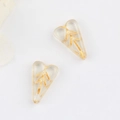 Macro view of transparent heart-shaped glass beads with gold leaf patterns for DIY jewelry - Clear