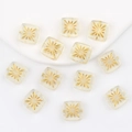 Macro detail of square clear glass beads with gold fireworks pattern for DIY jewelry - Clear