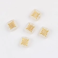 Macro shot of 10mm square glass beads with hand-painted gold fireworks pattern for DIY jewelry - White