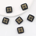 Detail of square glass beads with gold starburst pattern and central through-hole - Black