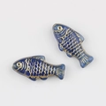 Macro detail of hand-painted blue Czech glass fish beads with gold-leaf scale patterns - Transparent Blue