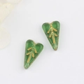 Macro detail of Czech glass heart leaf beads with vintage gold leaf tree patterns - Transparent Emerald