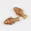 Detailed view of amber Czech glass fish beads with hand-painted gold scale patterns - Transparent Brown