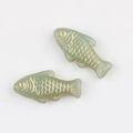 Detailed view of two light green glass fish beads with hand-painted gold scales - Light Green