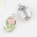 Detail of floral enamel pendant featuring green base, pink flower and star pattern back - Silver Base Green Flower