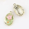 Detailed view of oval floral pendant with green enamel and star-textured gold backing - Gold Base Green Flower