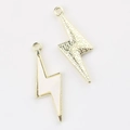 Macro view of gold-colored and white resin lightning bolt pendants for DIY jewelry - Gold White