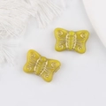 Makro-Detail von gelben Schmetterlingsglasperlen mit goldenen Gravuren für DIY-Schmuck - Gelb