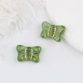 Detailed macro view of green butterfly glass beads with gold gilded textures for jewelry - Transparent Green