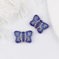 Detailed macro view of vintage blue and gold butterfly charms for DIY jewelry making - Blue