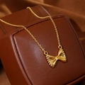 Gouden vlinderstrik ketting met farfalle hanger op bruin lederen sieradendoosje - 18K goud