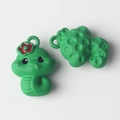 Macro detail of cute green snake charms with red flower and textured back for DIY jewelry - Green