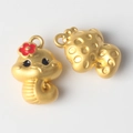 Close-up of cute golden zodiac snake charms with red flower and textured details - Matte Gold