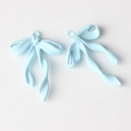 Detalle de dos colgantes de lazo azul claro mate para la creación de joyas DIY - Azul