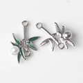 Detailed view of bamboo leaf pendants with green enamel and pearls for DIY jewelry - Silver
